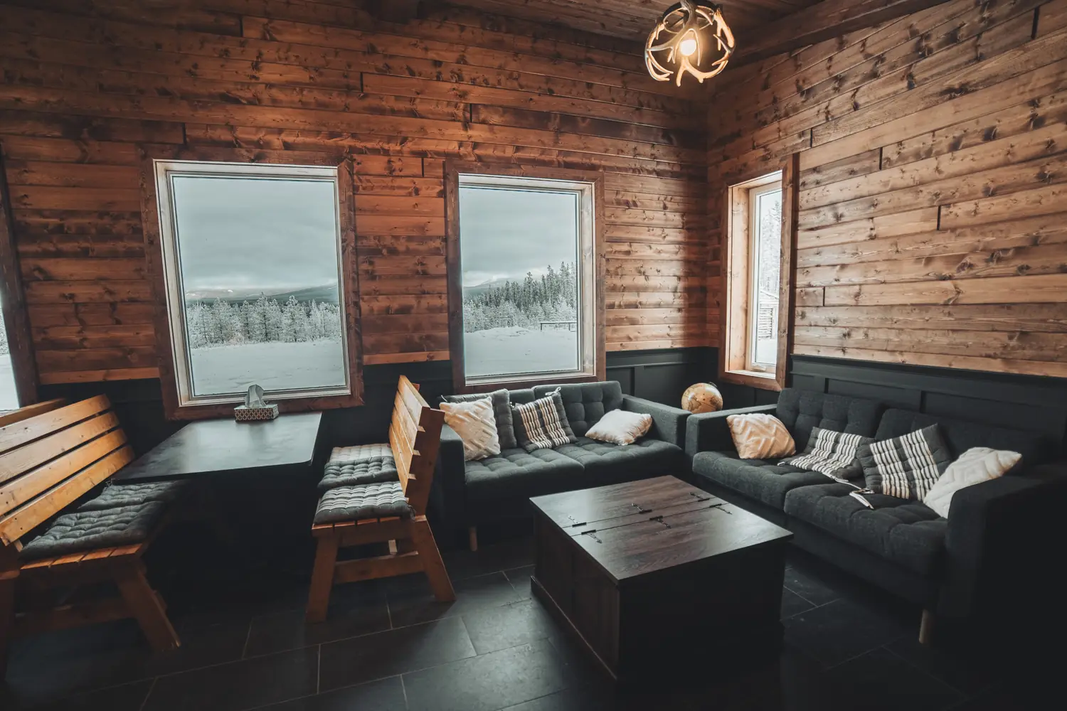 Sofas, cushioned wooden benches and window tables inside the cedar-walled Aurora Lounge.