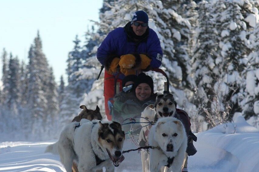 Guests enjoying a dog sledding trip in the Yukon Wilderness